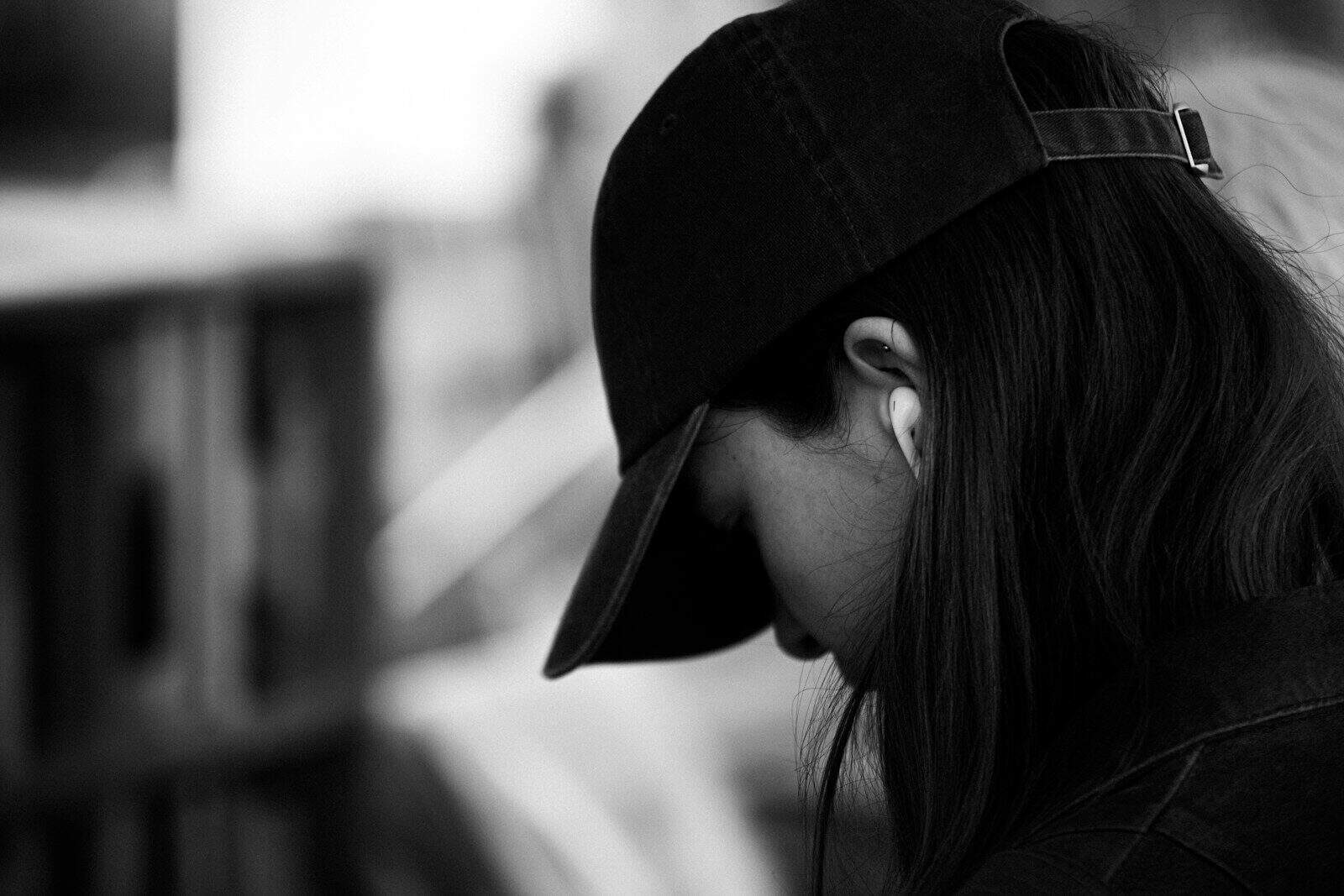 A person wearing a baseball cap and earphones