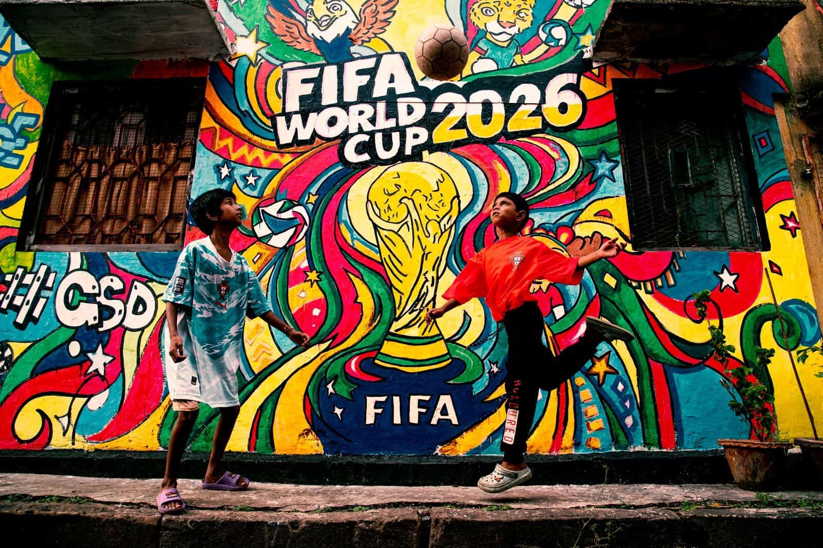 Vibrant mural of FIFA World Cup 2026 with kids playing soccer in the foreground.