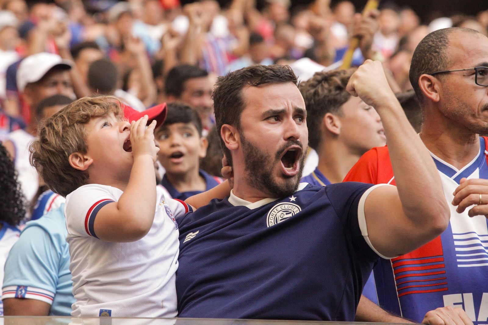 Energetic crowd cheering passionately at a live sports event, capturing excitement and unity.
